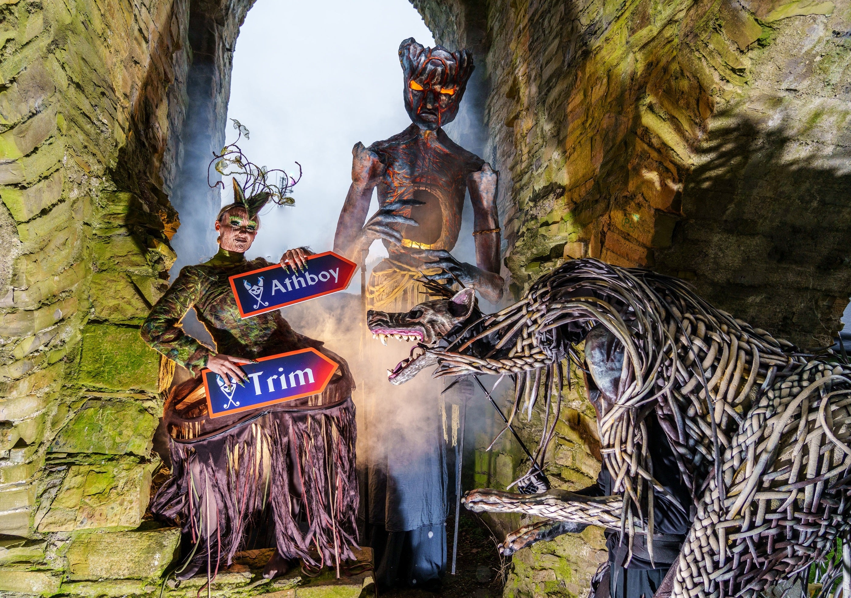 A person in costume holding signs