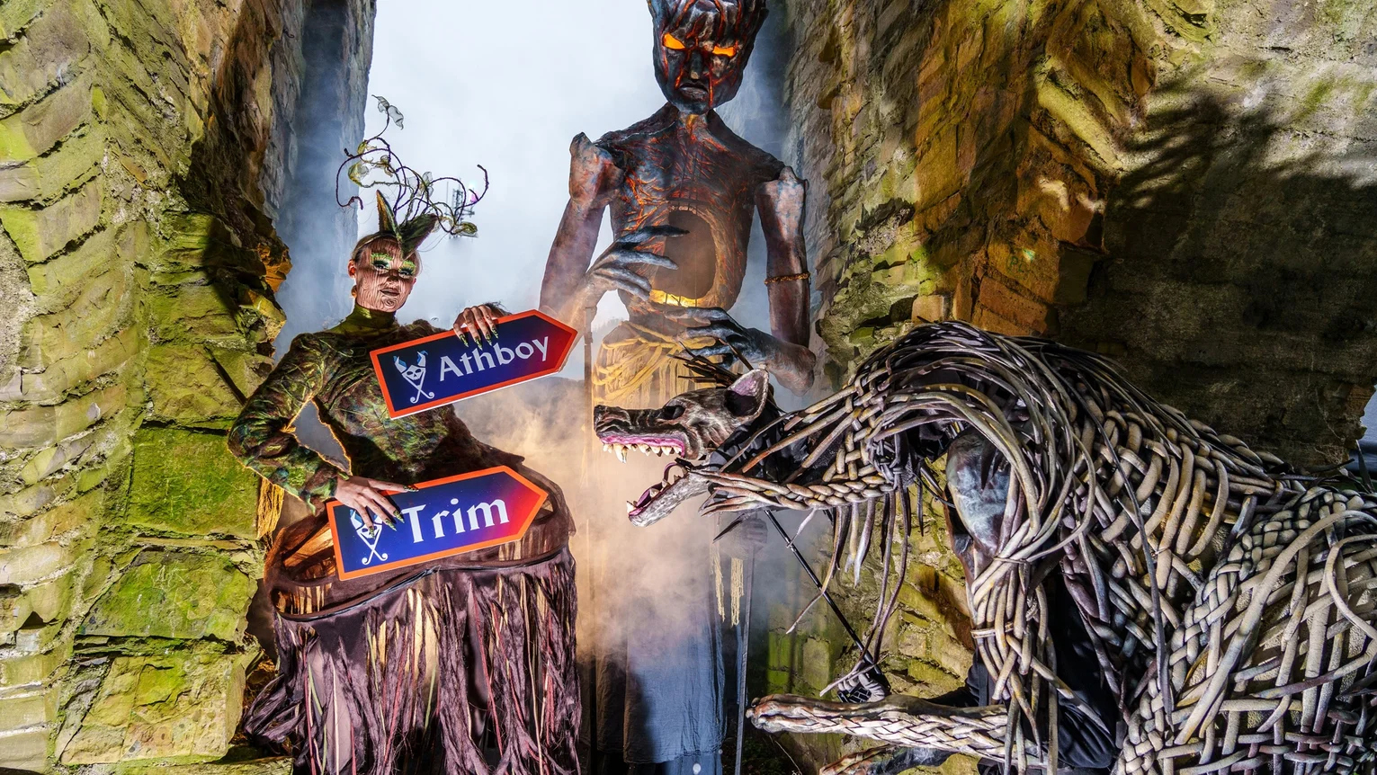 A person in costume holding signs