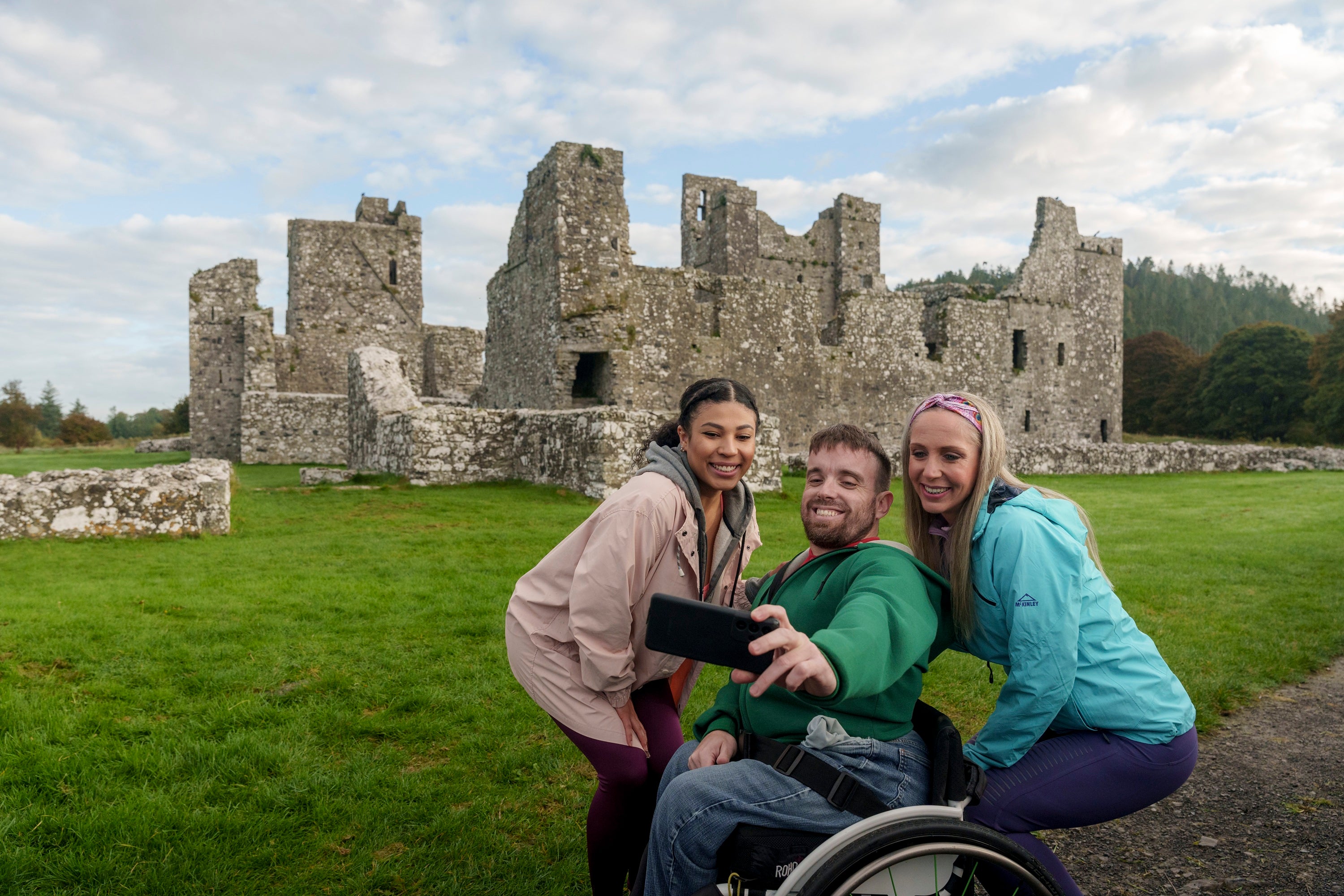 A group of people taking a selfie in front of a stone castle