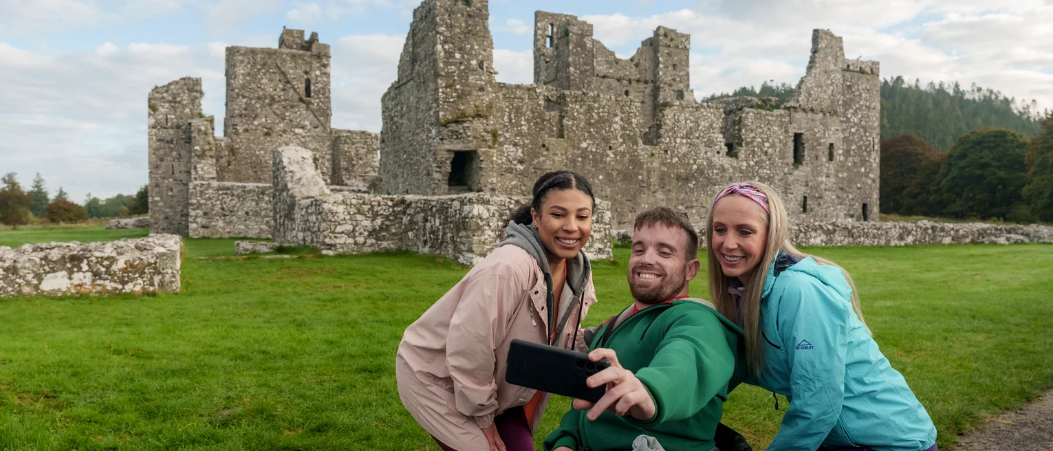 A group of people taking a selfie in front of a stone castle