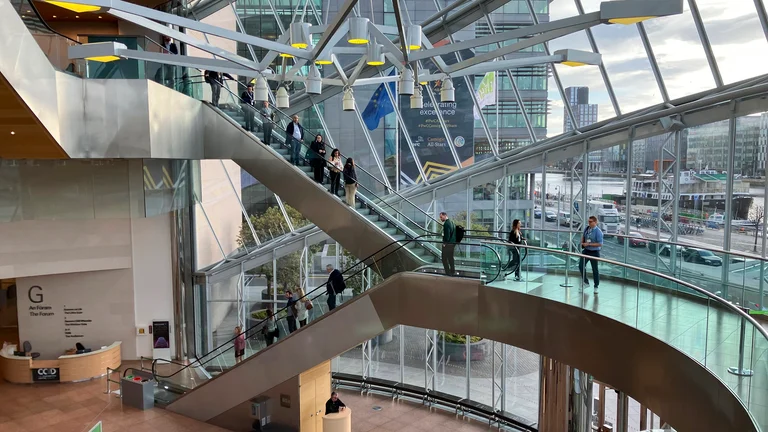 A group of people on escalators in a conference building