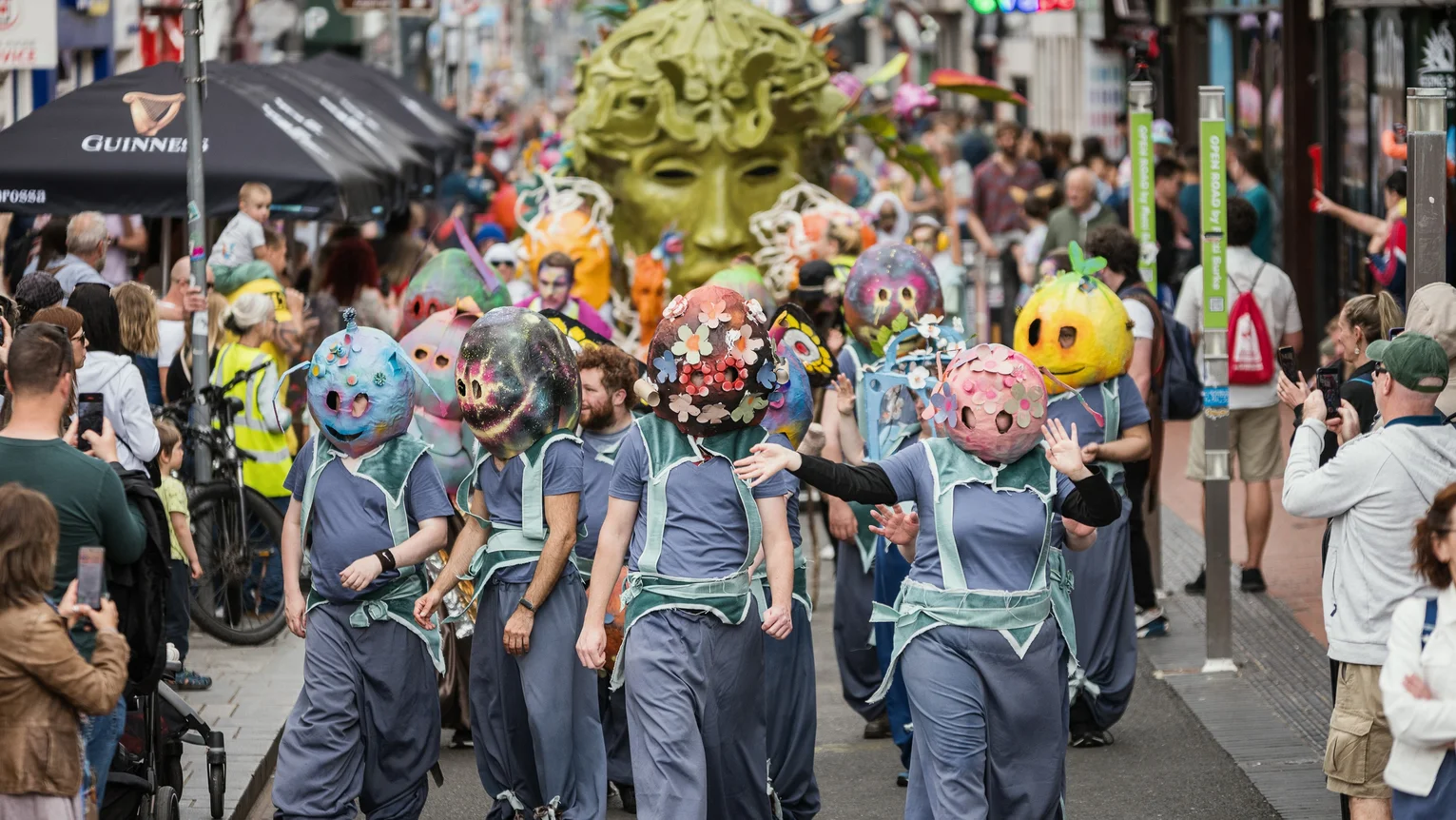 A group of performers wearing masks in a parade