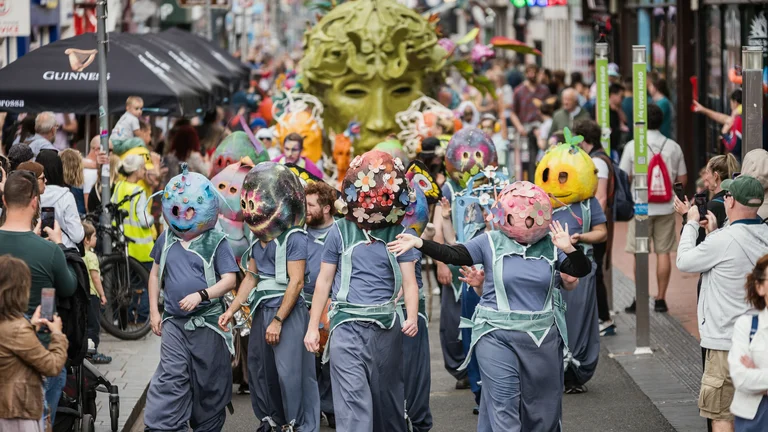 A group of performers wearing masks in a parade