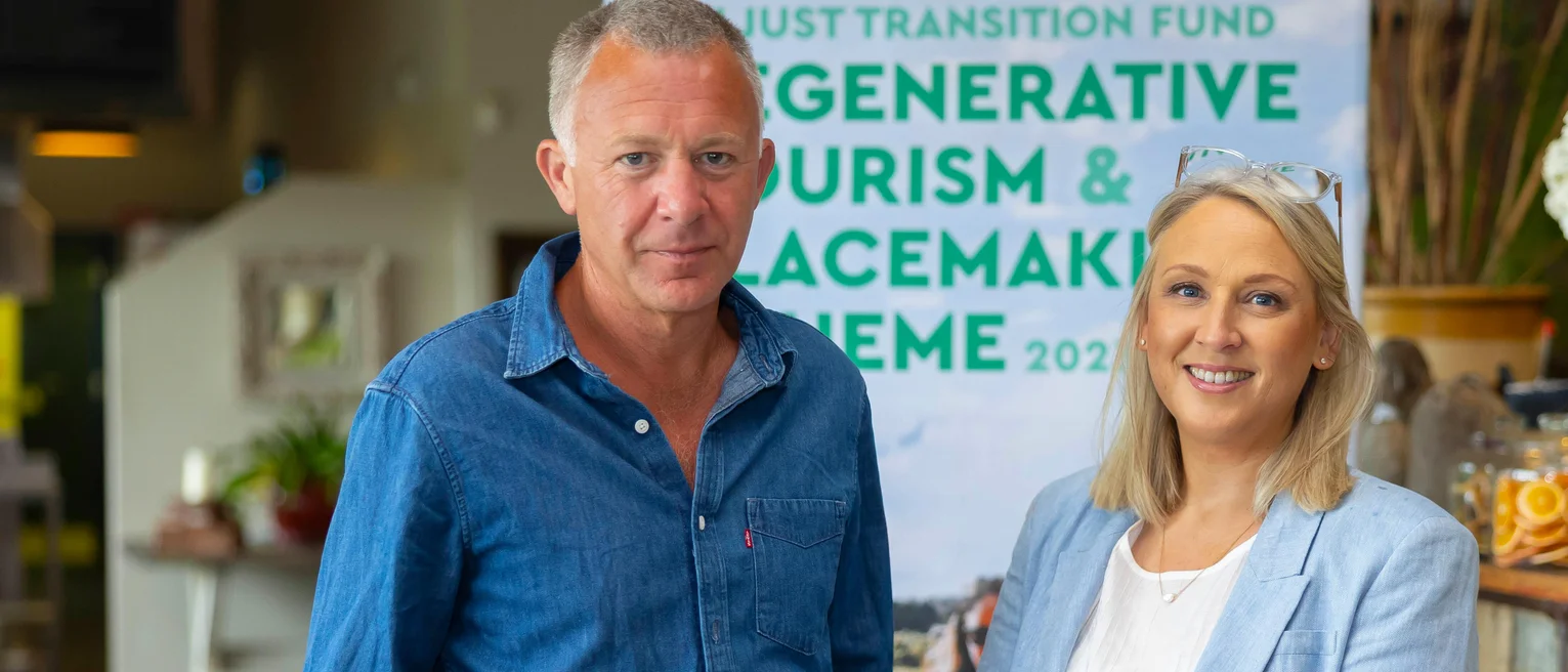 A man and woman standing in front of a sign