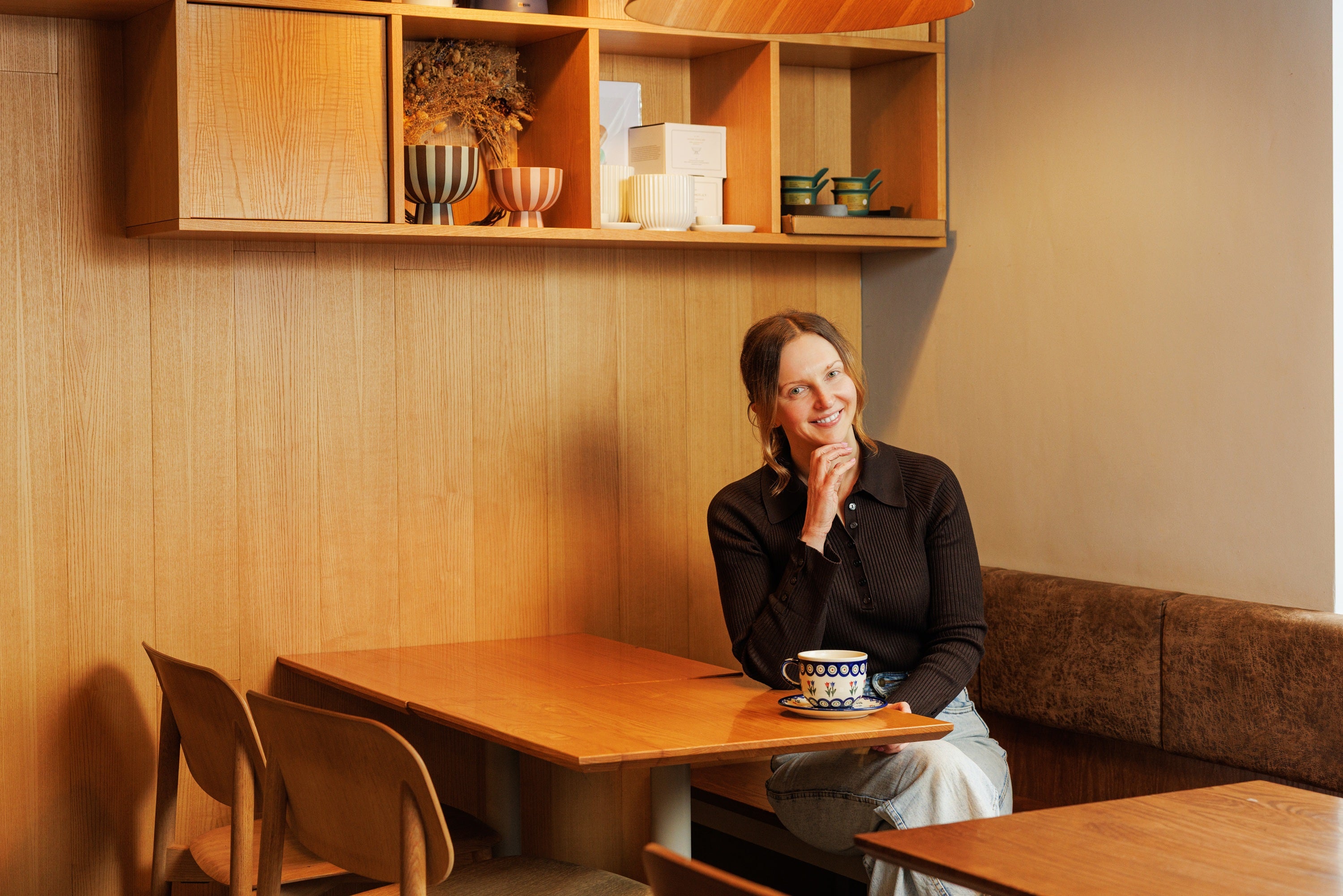 A woman sitting at a table with a cup of coffee