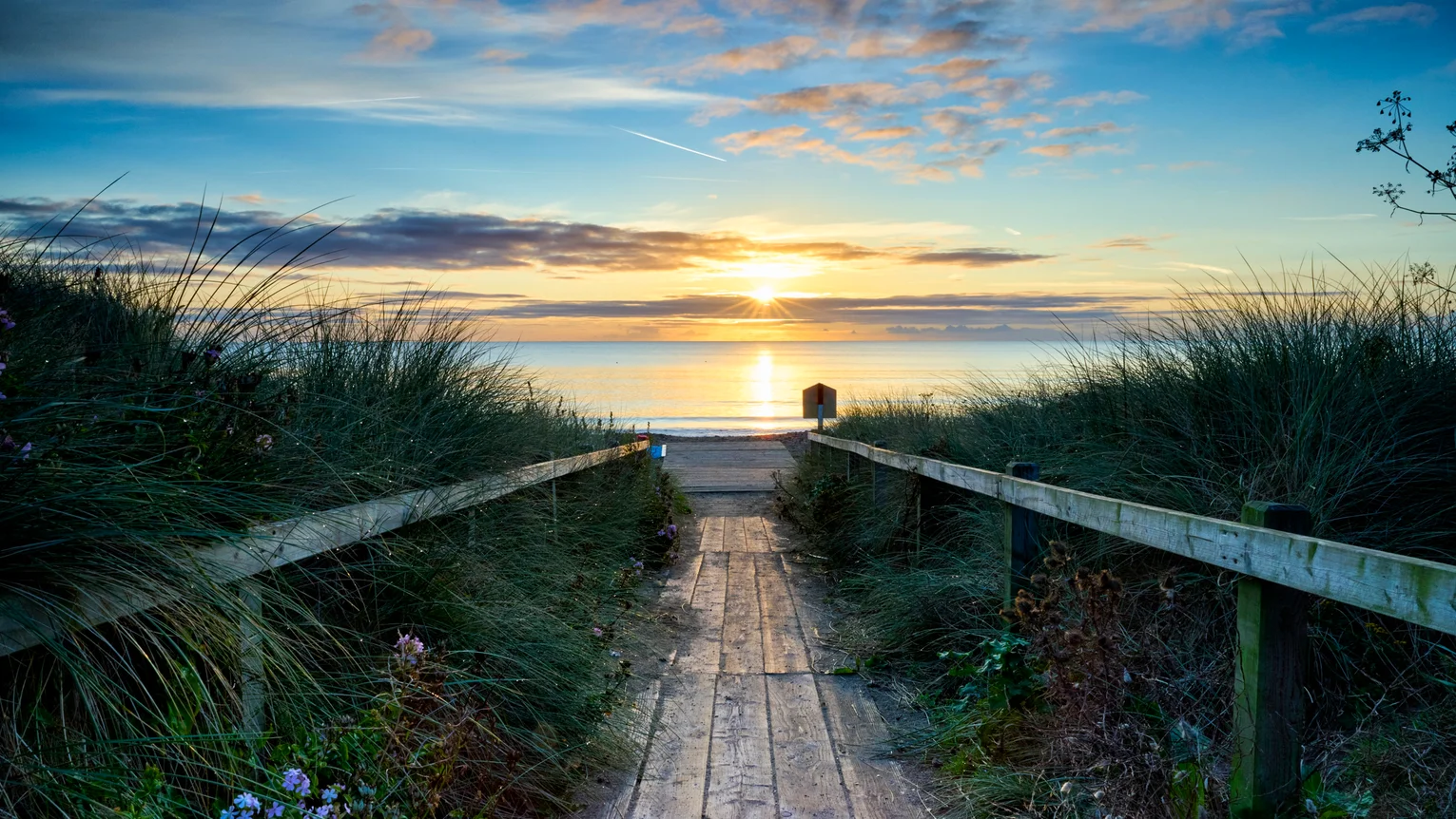 A wooden walkway leading to a beach