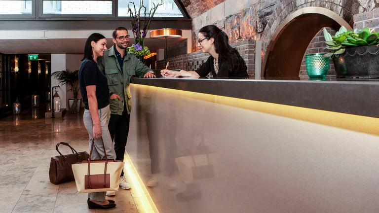 Two adults checking out of a hotel.