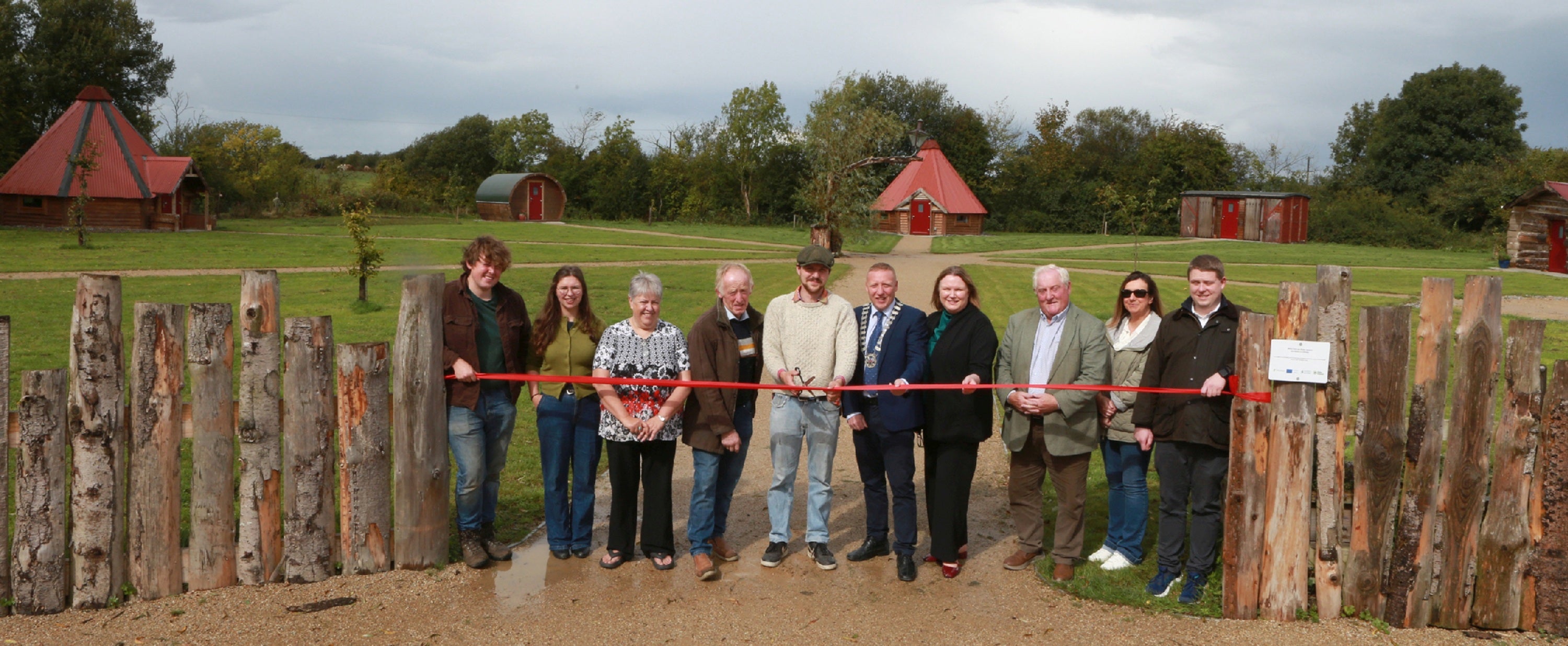A group of people standing in front of a red ribbon