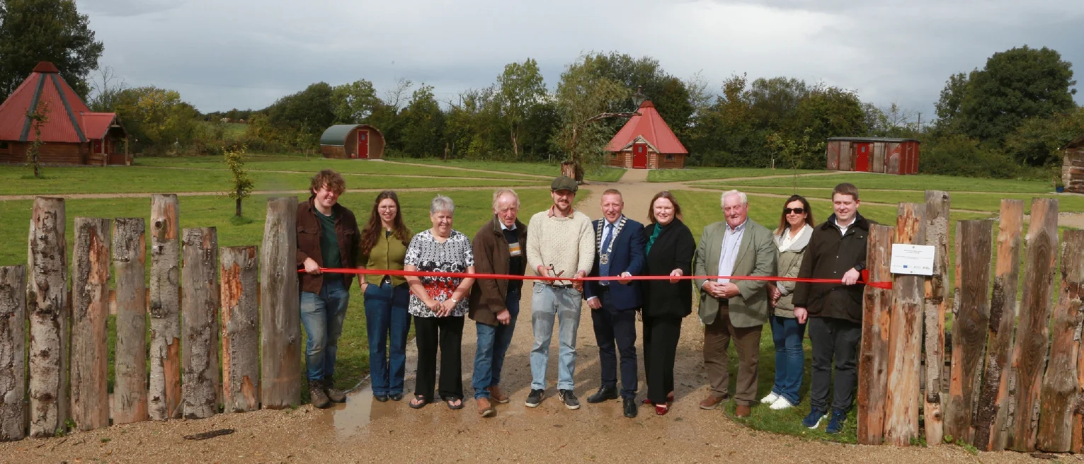 A group of people standing in front of a red ribbon