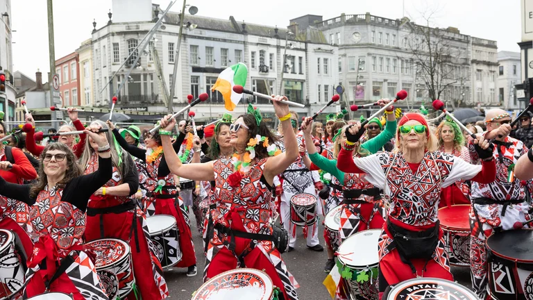 A group of women in colorful clothing holding drums