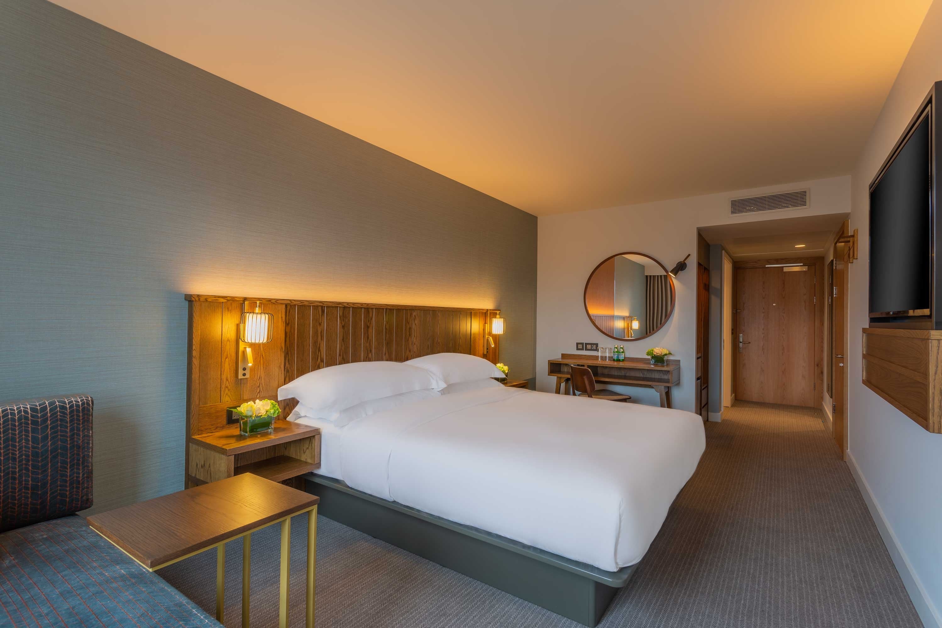 A bedroom with a bed and a mirror