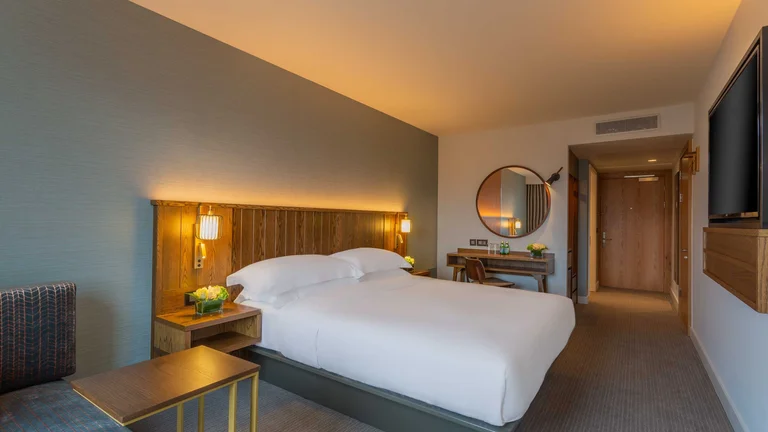 A bedroom with a bed and a mirror