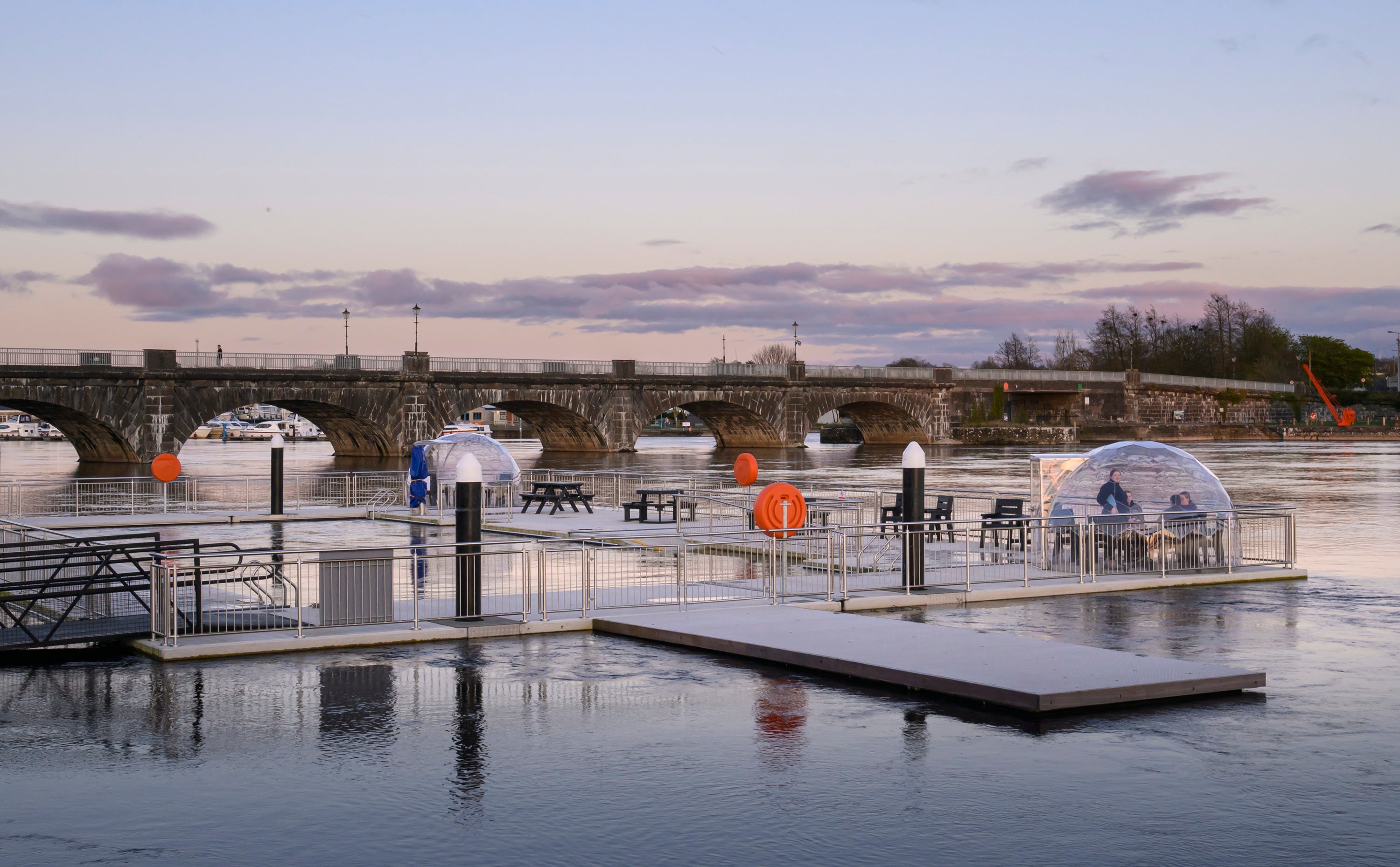 A floating outdoor swimming pool and a bridge in the background