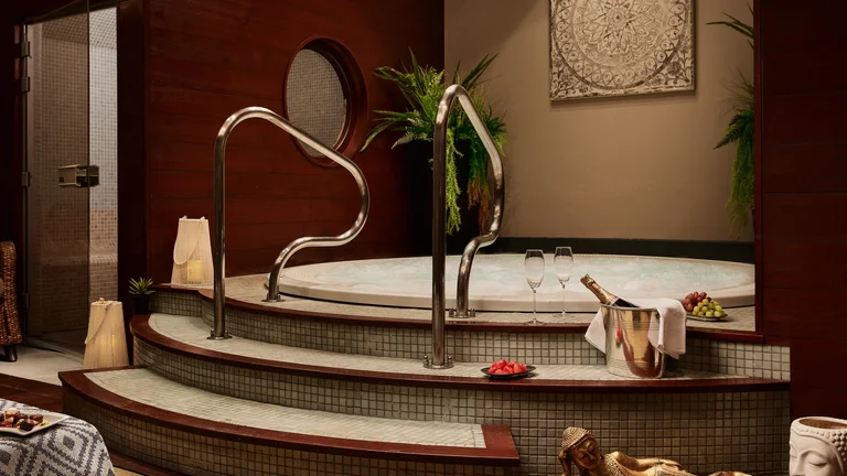 A hot tub with a tub and wine glasses