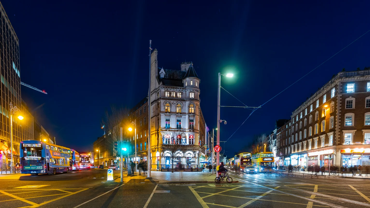 A street with a building and traffic lights at night