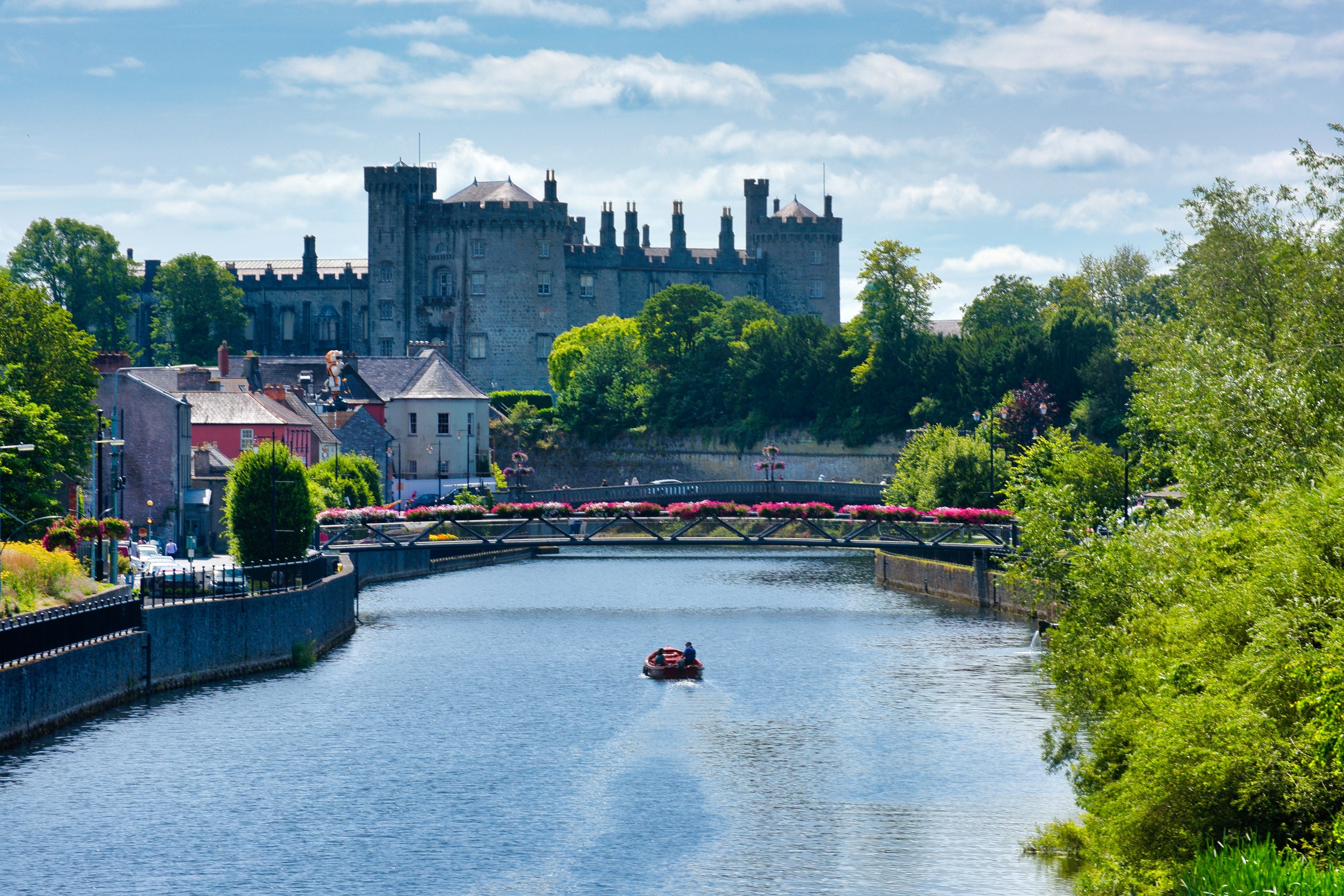 A boat on a river with a castle in the background