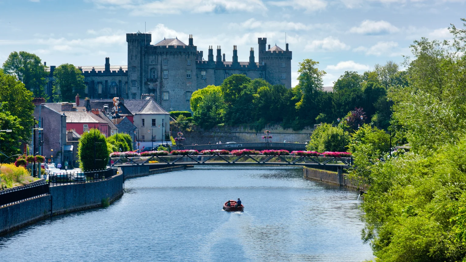 A boat on a river with a castle in the background
