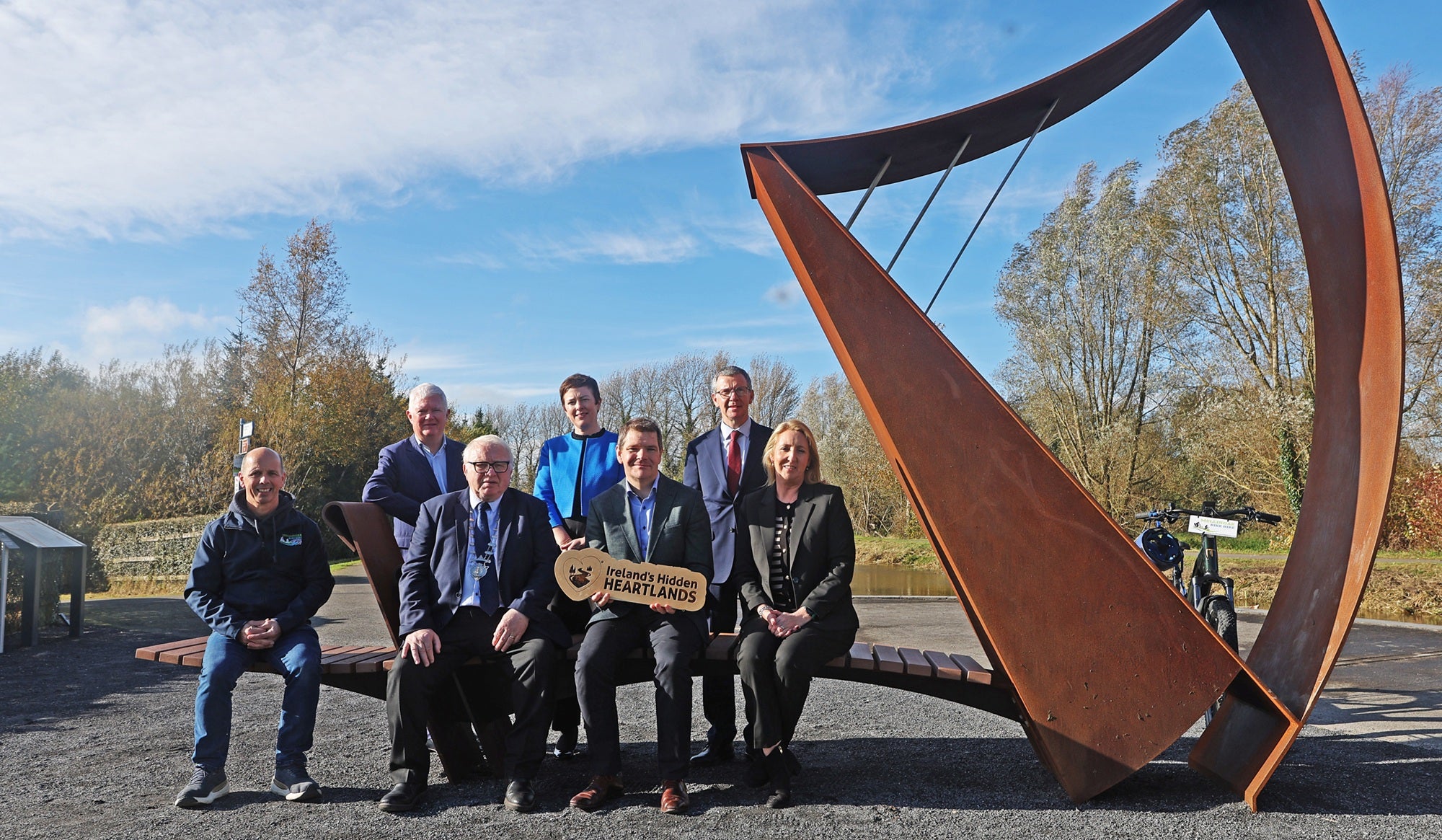 Group of people in front of a large ornamental harp on the Royal Canal Greenway, Alan Maye, Mullingar Bike Hire;Cllr Bill Collentine; Minister Peter Burke;Sharon Lavin, Waterways Ireland;John McDonagh, Waterways Ireland; Grainne Cornally, Fáilte Ireland;Barry Kehoe, Westmeath CoCo