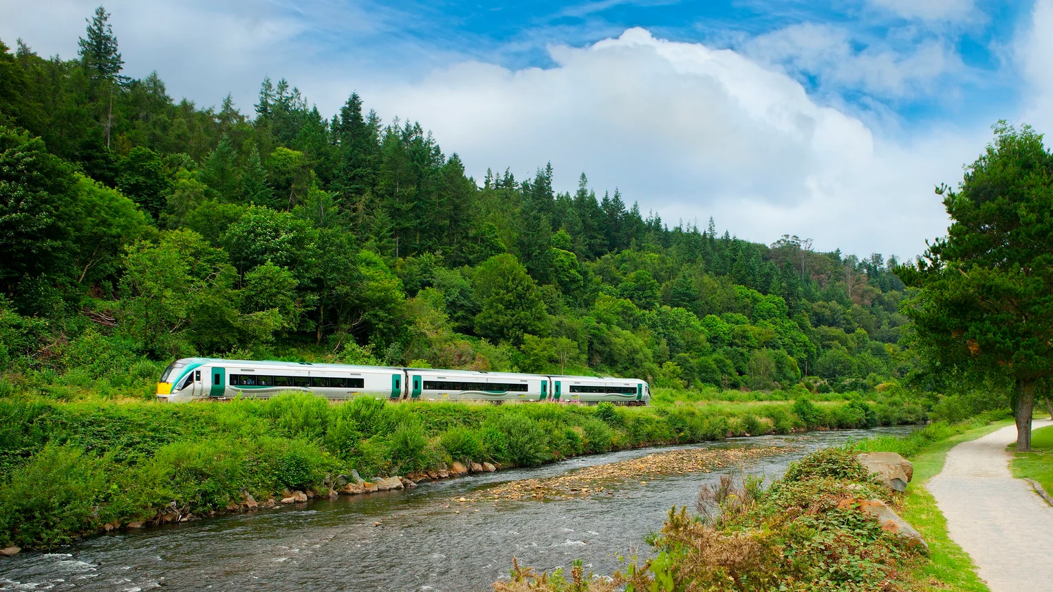 A train on the tracks by a river