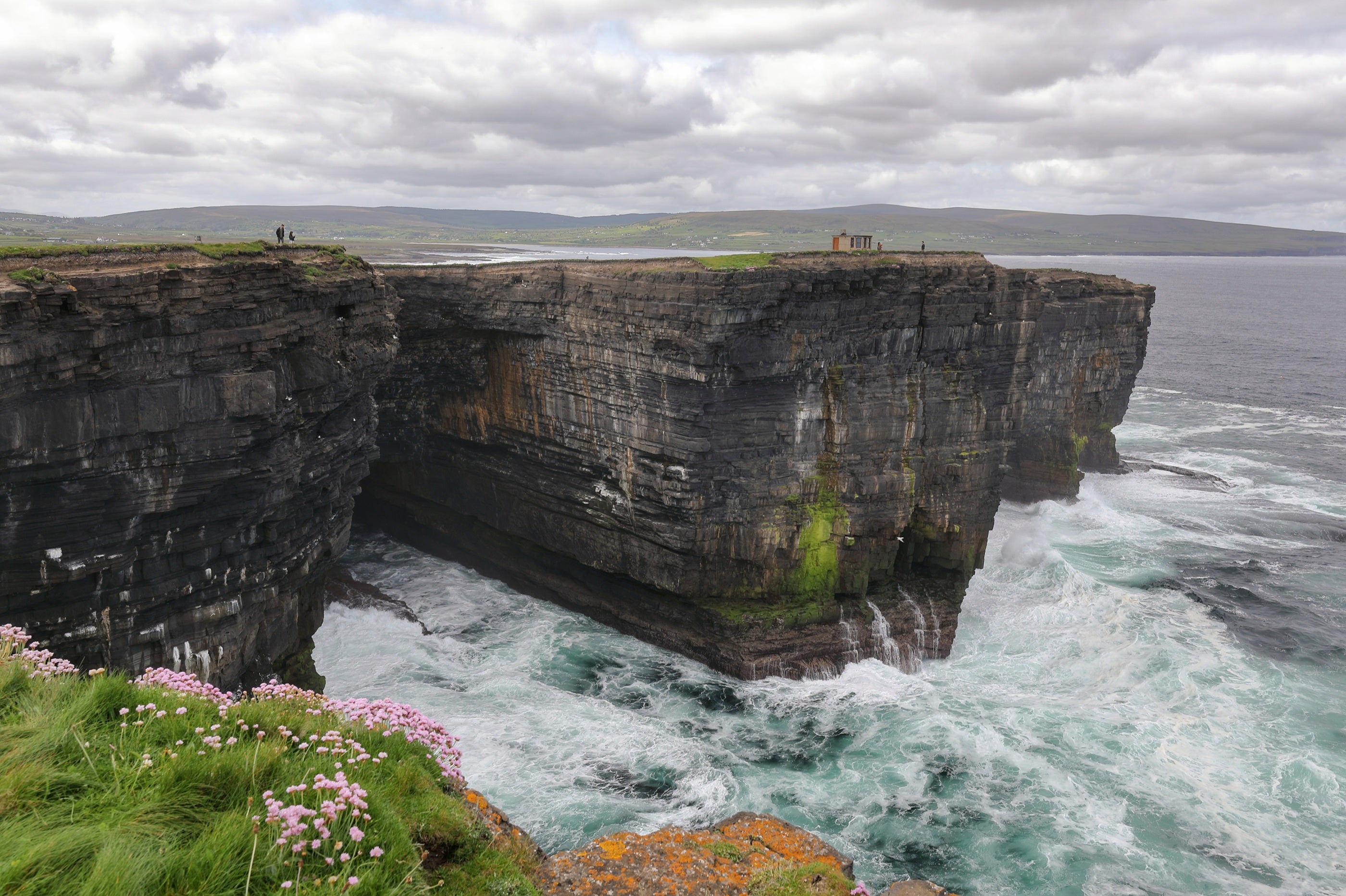 A cliff with water crashing into it