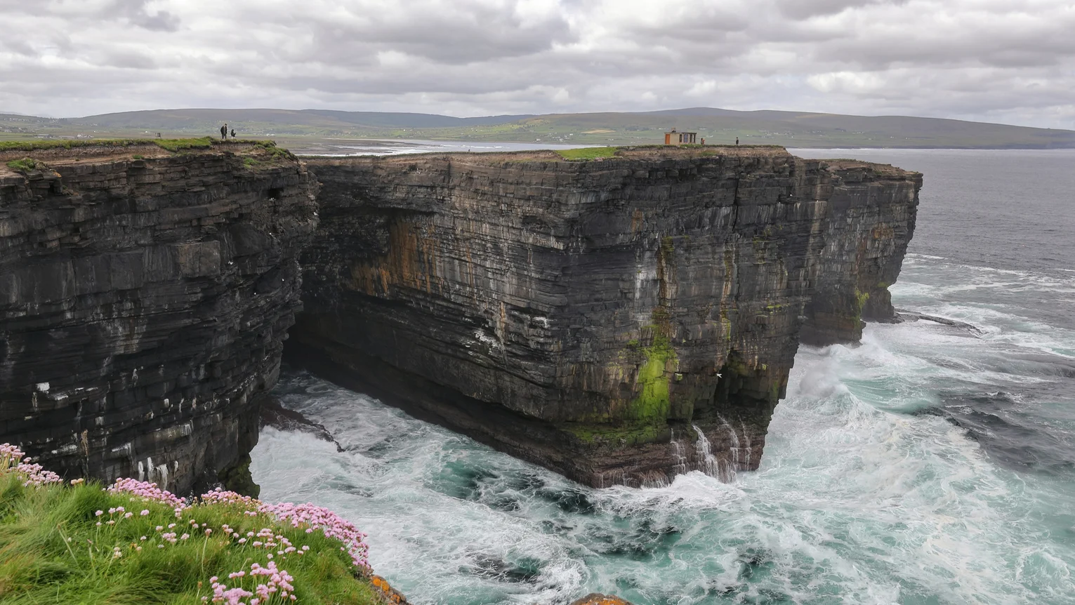 A cliff with water crashing into it