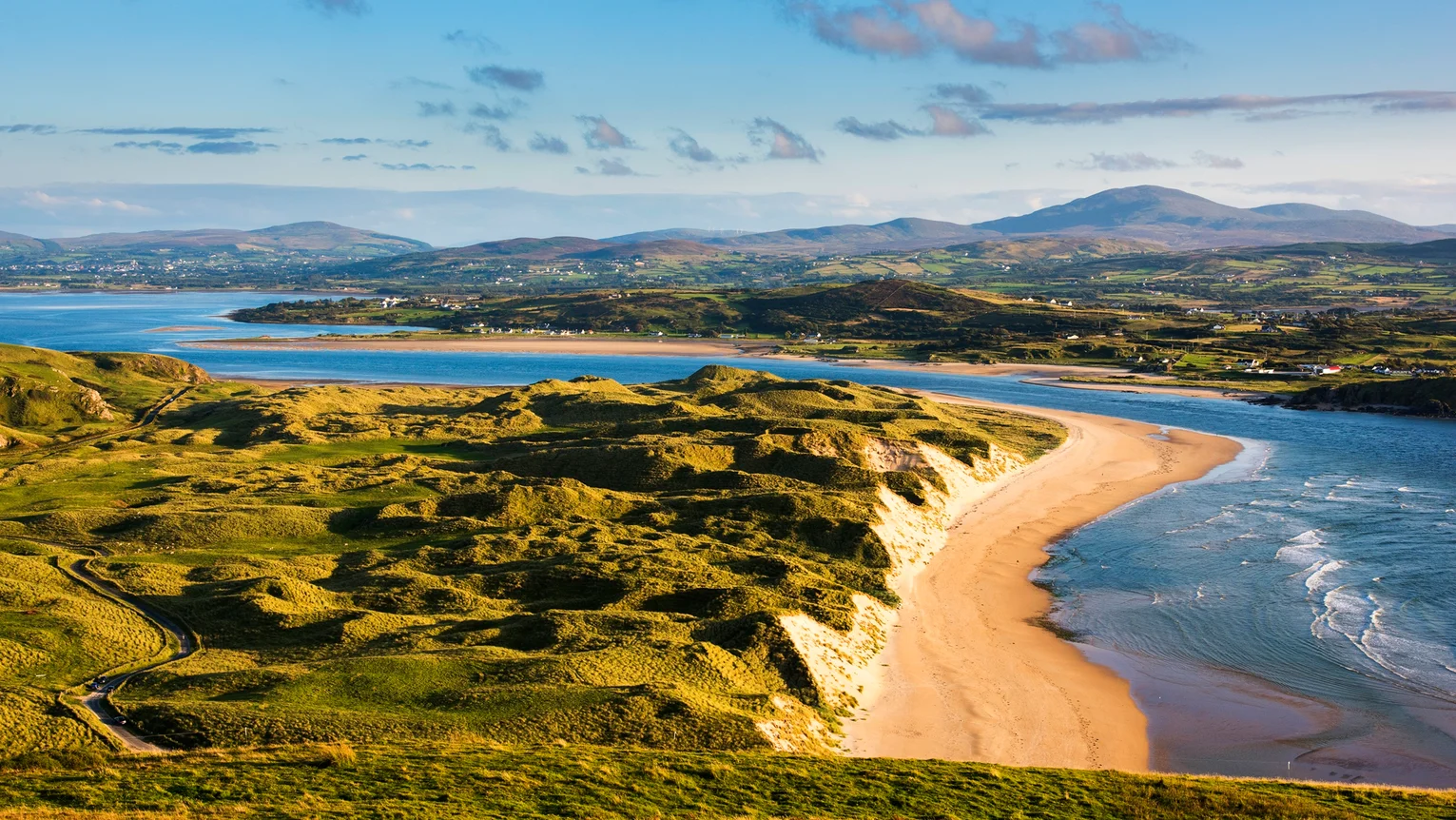A beach with a body of water and hills