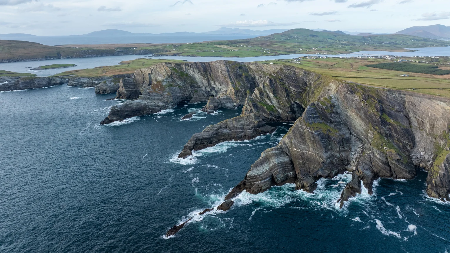 A large rocky cliff above water